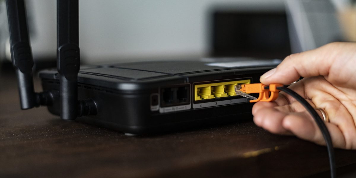 man-plugging-ethernet-cable-wireless-router-scaled.jpg - StiriFresh